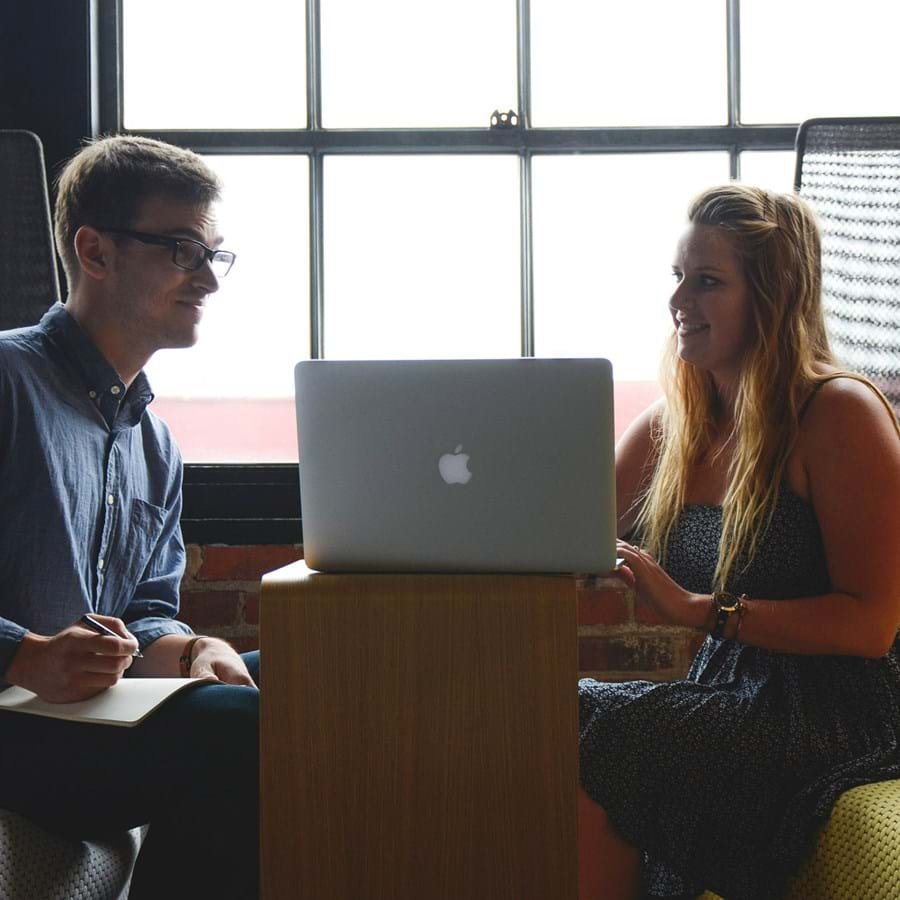 ein Mann und eine Frau führen ein Gespräch an einem Laptop