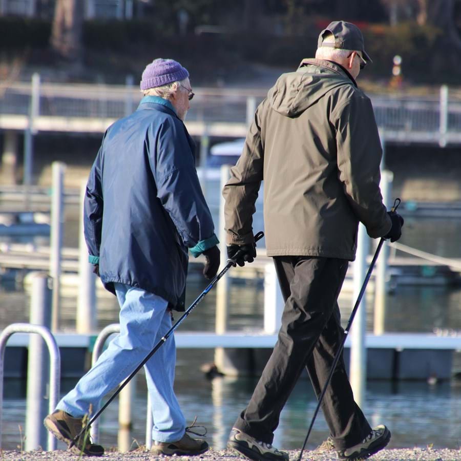 Zwei Senioren gehen am Rand eines Sees entlang