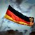 Deutsche Flagge weht vor dunklem Himmel
