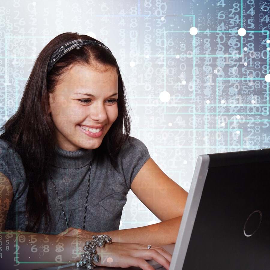Mädchen arbeitet lächelnd am Laptop mit viele Zahlen im Hintergrund