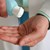 ein medizinisch Angestellter desinfiziert sich die Hände