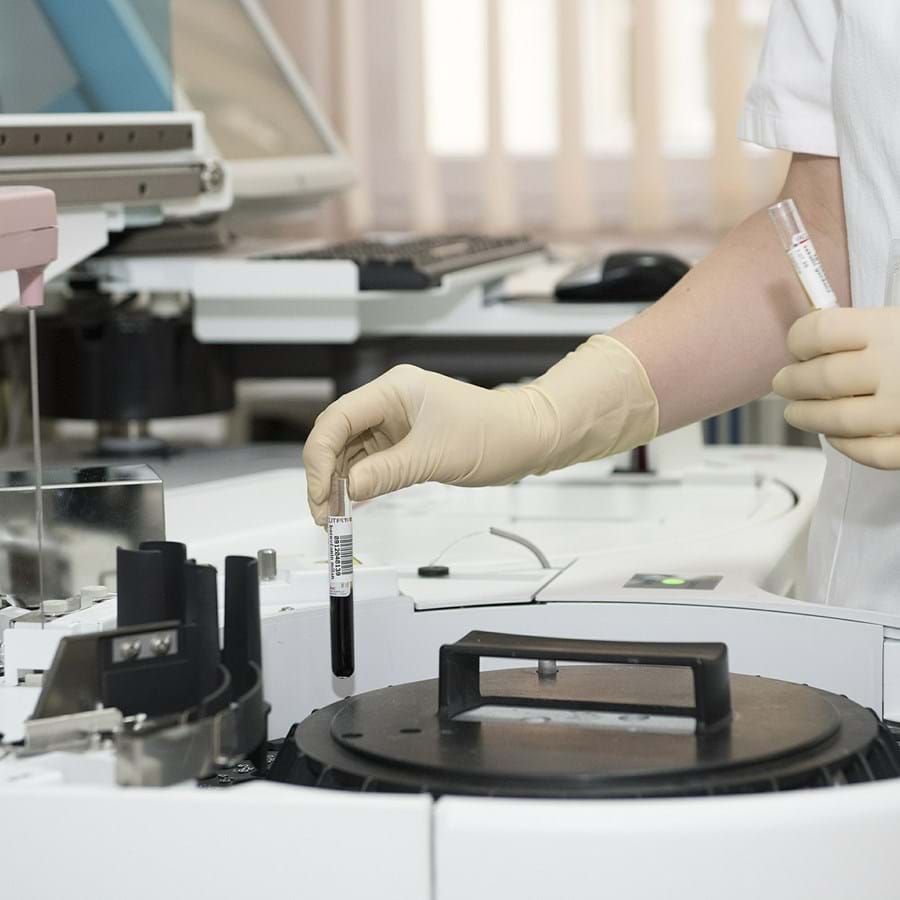 Mitarbeiter untersucht mit einem Gerät eine Flüssigkeit im Labor